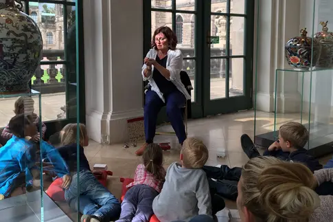 Foto, Geschichtenerzählerin umringt von Kindern in der Ausstellung