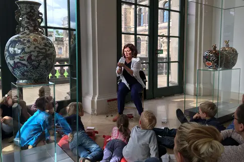 Kinder bekommen ein Objekt der Porzellansammlung erklärt